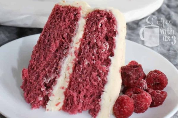 A slice of raspberry cake on a white plate, perfect for those who love sweet treats or are looking for a new dessert recipe.