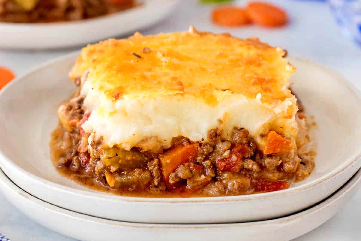 A plate of shepherd's pie with carrots and meat on it.