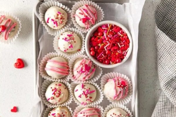 Red Velvet Valentine's day truffles in a tray with sprinkles.