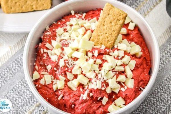 A bowl of red velvet dip served with crackers and graham crackers, perfect for indulging in decadent desserts.