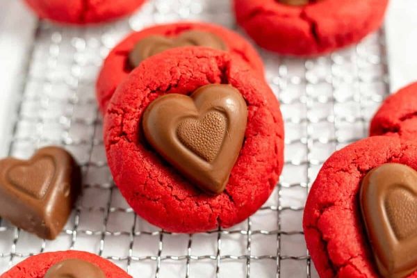 Red Velvet heart shaped cookies on a cooling rack.