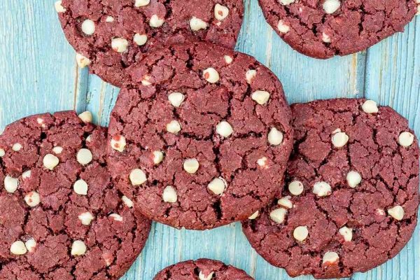 Red velvet cookies with white chocolate chips on a blue background is a heavenly combination. These delectable desserts are perfect for satisfying any sweet tooth. Each cookie is infused with the rich flavor of red velvet