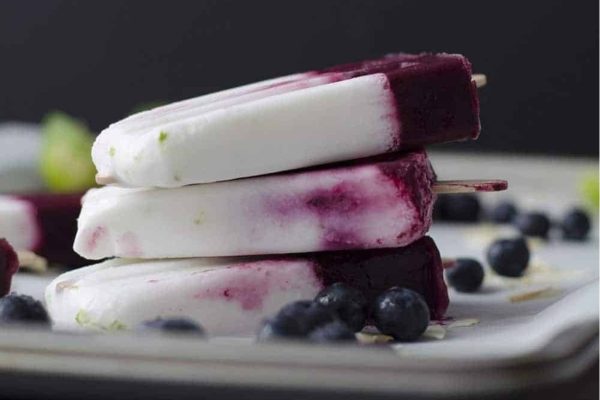 Three blueberry popsicles on a plate featuring Coconut.