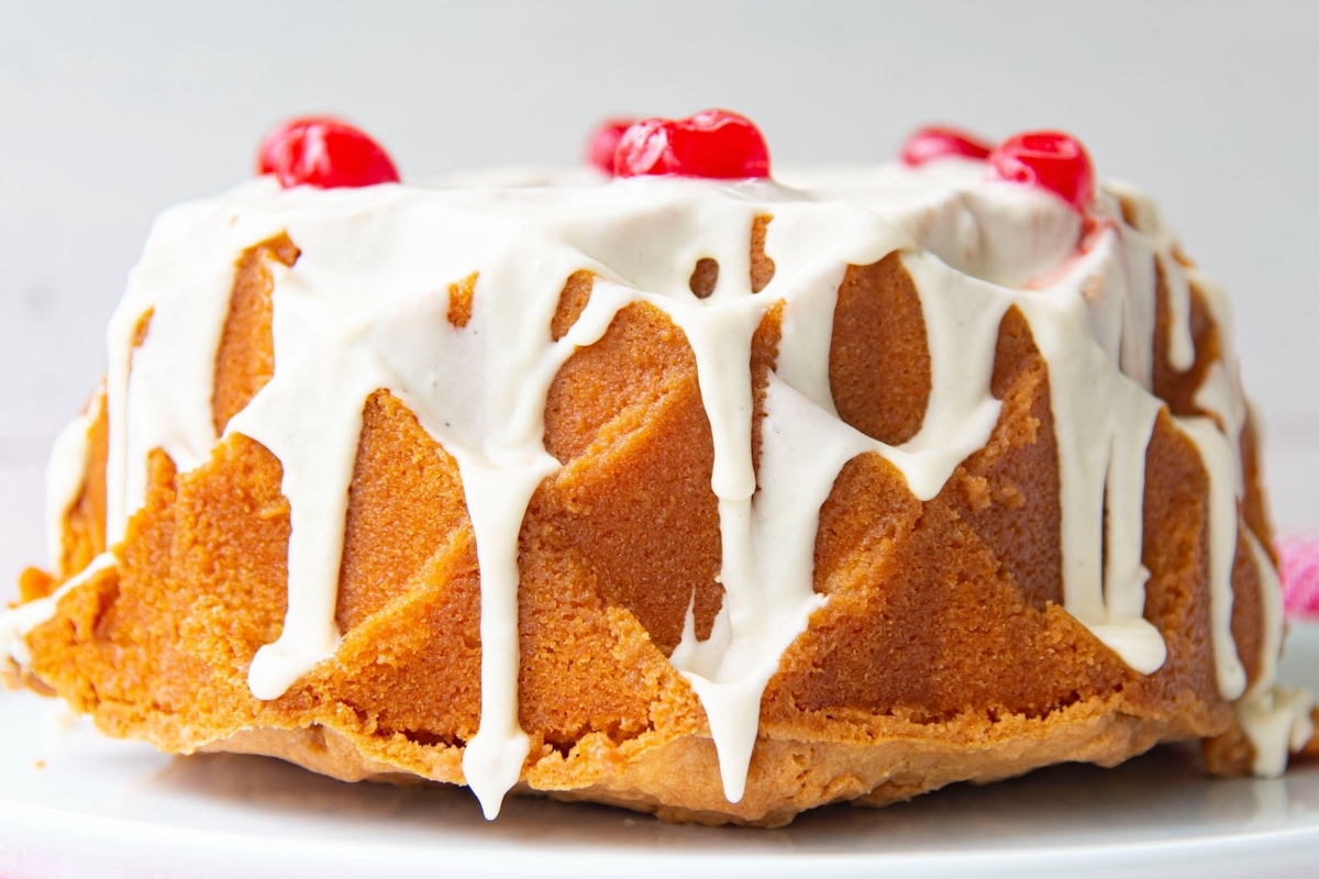 A delicious bundt cake decorated with cherries on top.