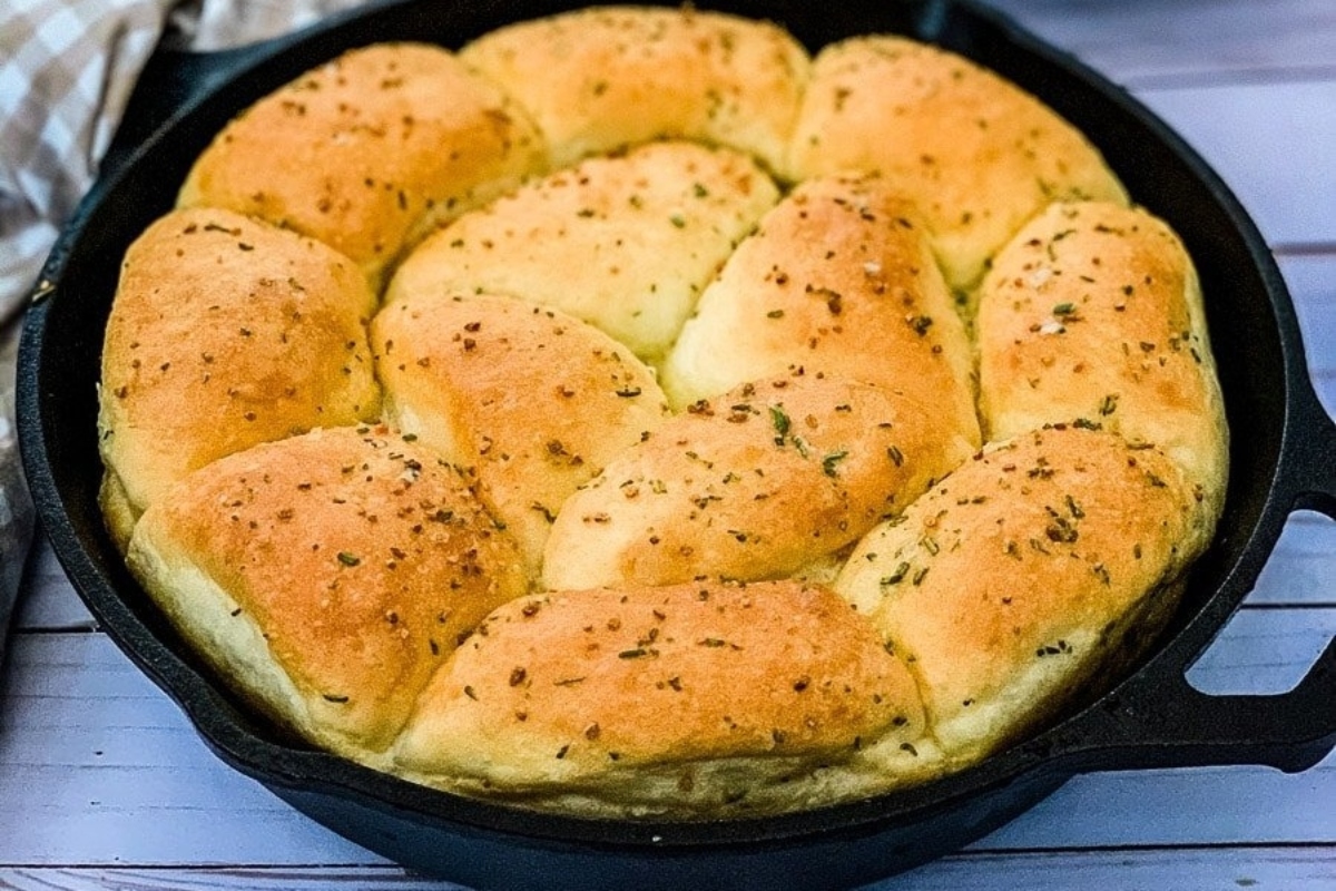 A cast iron skillet filled with a freshly baked loaf of bread.