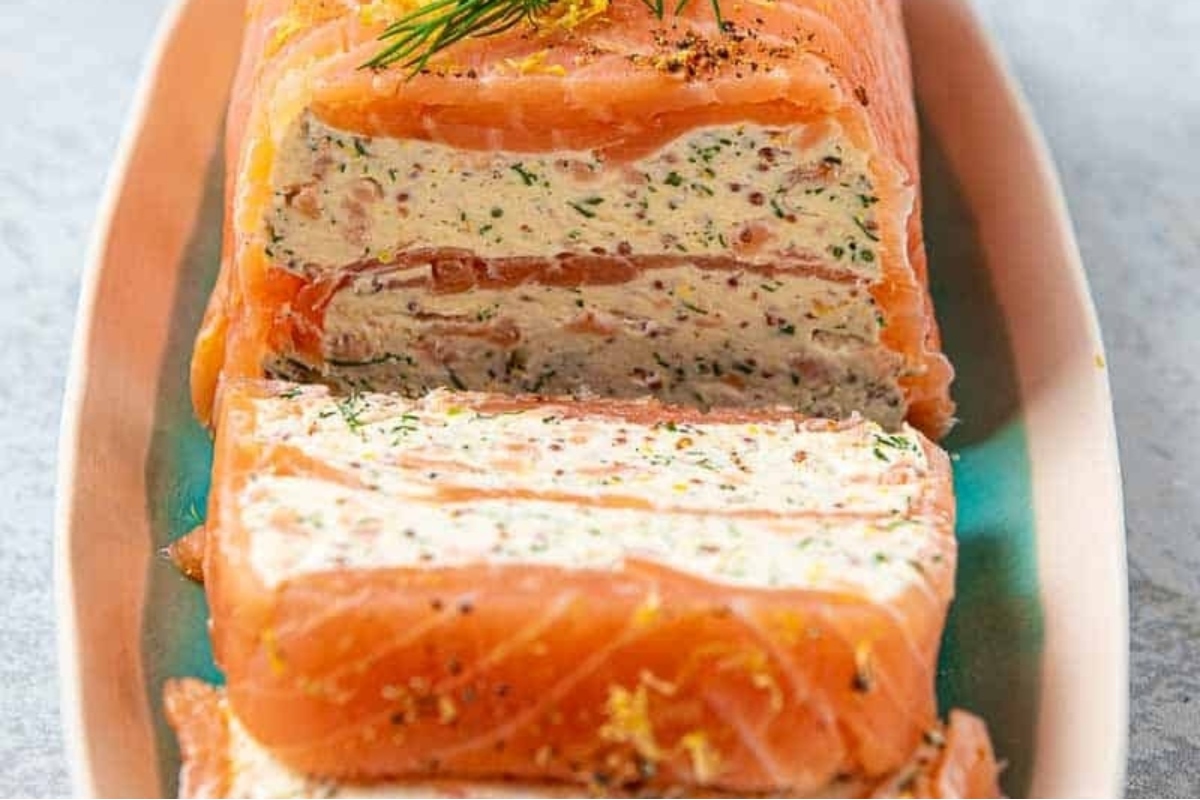 Festive appetizer of sliced salmon on a plate garnished with a sprig of dill, perfect for holiday parties.