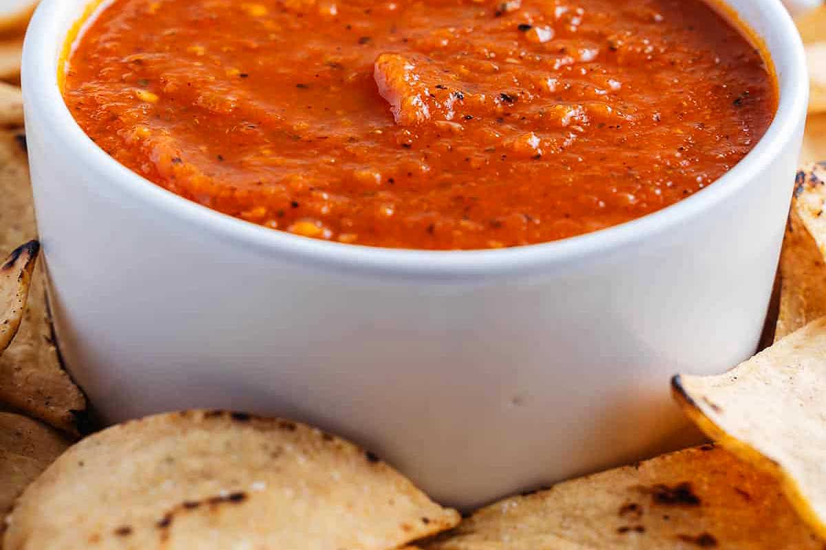A bowl of salsa with chips and tortilla chips, perfect for tomato recipes enthusiasts.