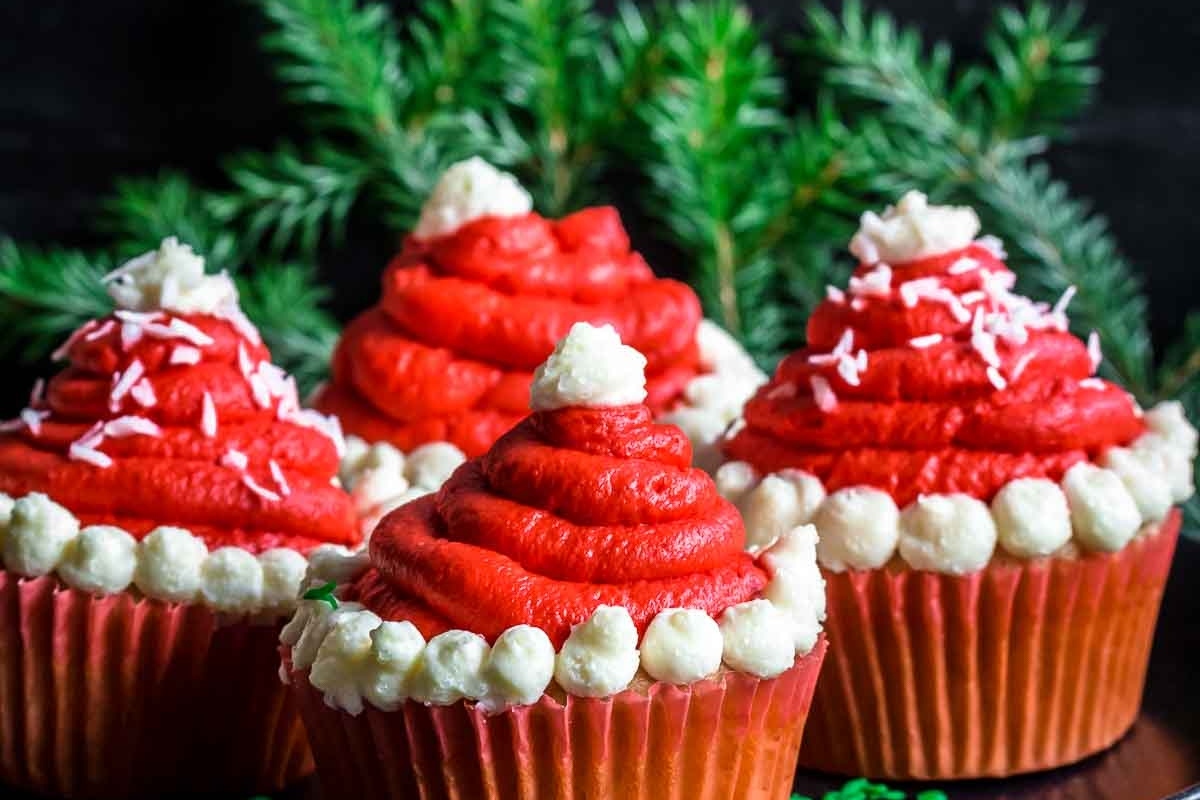 Cute Christmas cupcakes with santa hats on a plate.