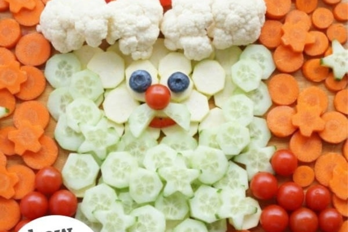 Christmas Santa Claus made of vegetables and carrots, displayed on a charcuterie board.