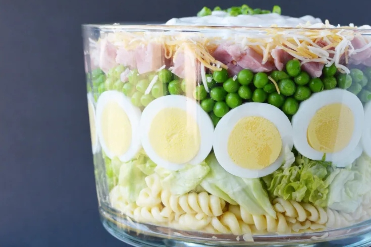 Frozen peas are used to create a delicious and refreshing ham and cheese salad, conveniently packed in a glass jar. With this recipe, you can enjoy a healthy and convenient meal on the go.