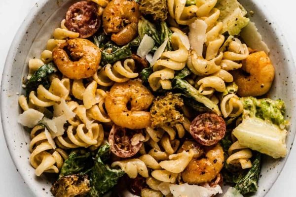 A bowl of kid-friendly pasta with shrimp and greens that parents will love.