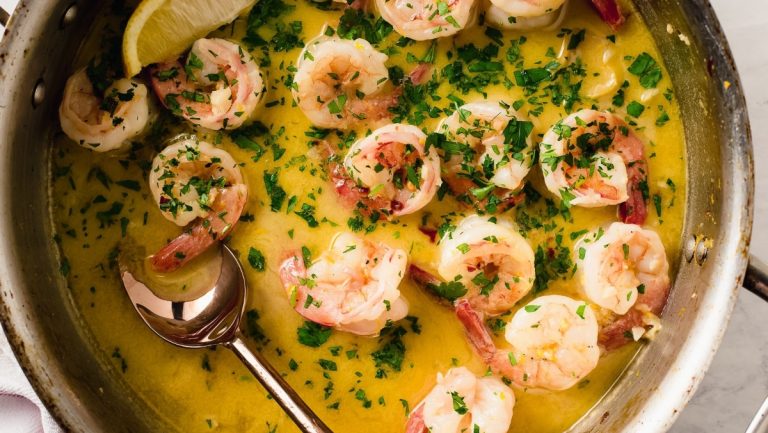 Shrimp in a pan with lemon and parsley.