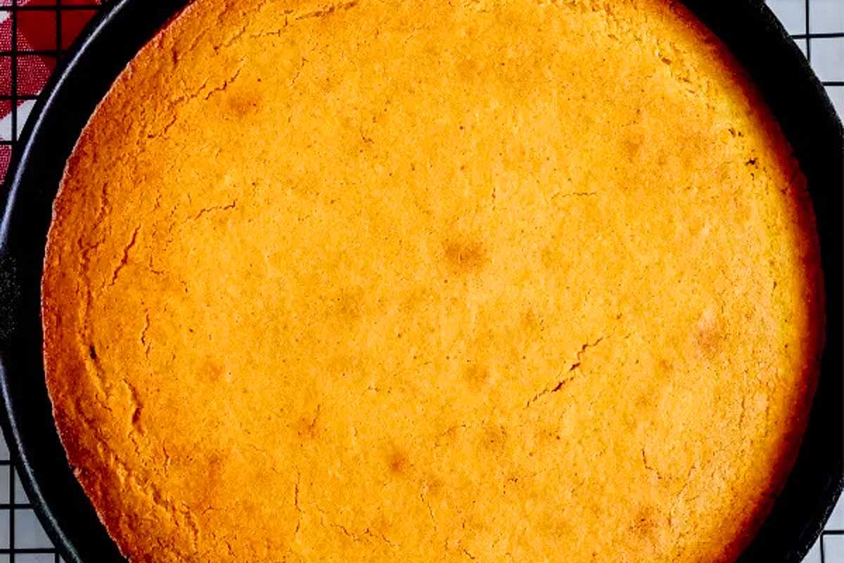 Cornbread in a pan on a cooling rack.