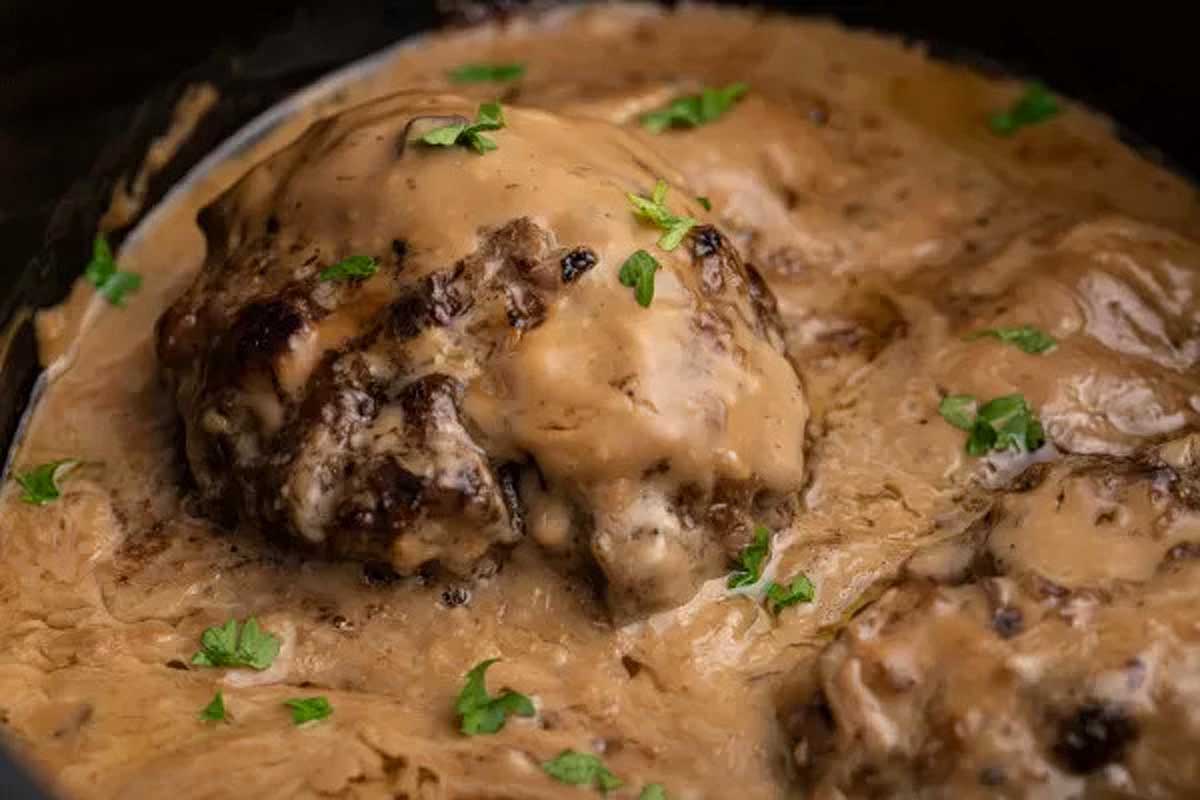 Meatballs covered in gravy in a slow cooker.