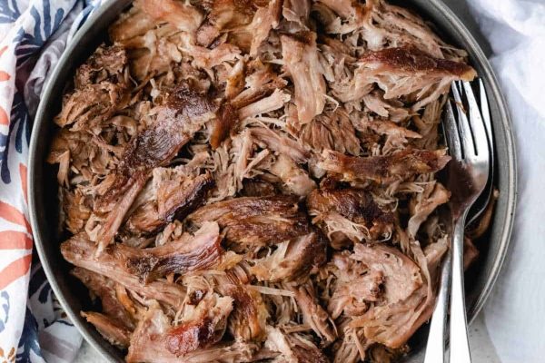 Pulled pork in a skillet with a fork.