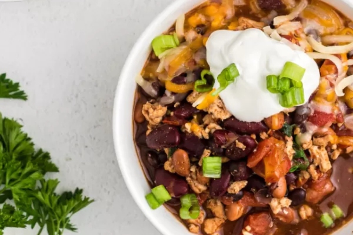 Ground Turkey Chili in a white bowl with sour cream.
