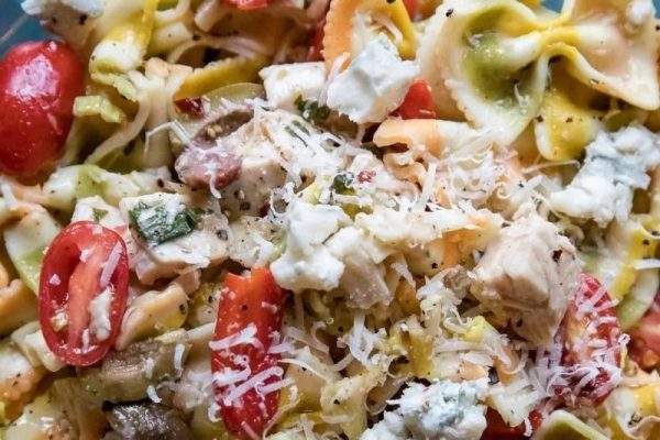 A flavorful pasta salad recipe featuring tender chicken, juicy tomatoes, and creamy cheese.
