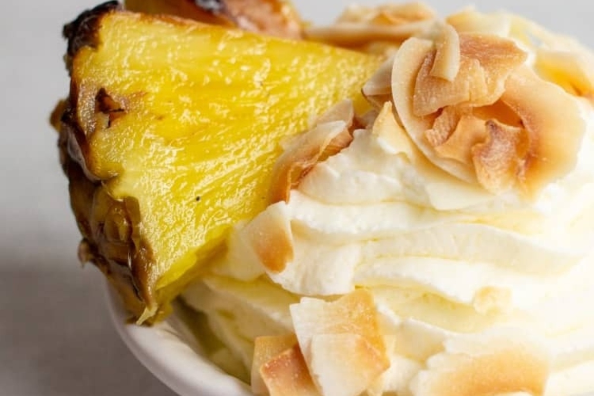 A bowl of ice cream with a Hawaiian-inspired slice of pineapple.