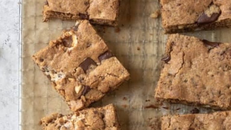 Chocolate s'mores bars on a baking sheet with marshmallows.