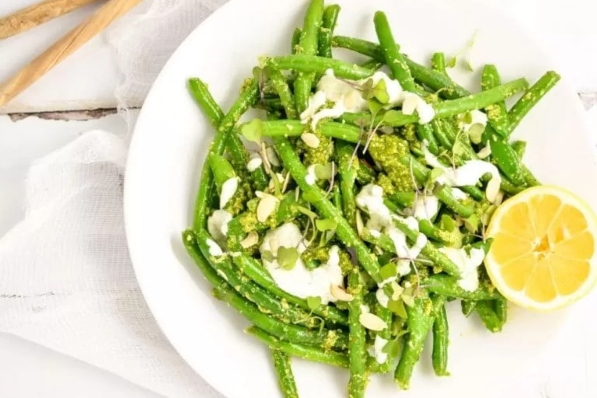Italian green beans with pesto on a white plate.