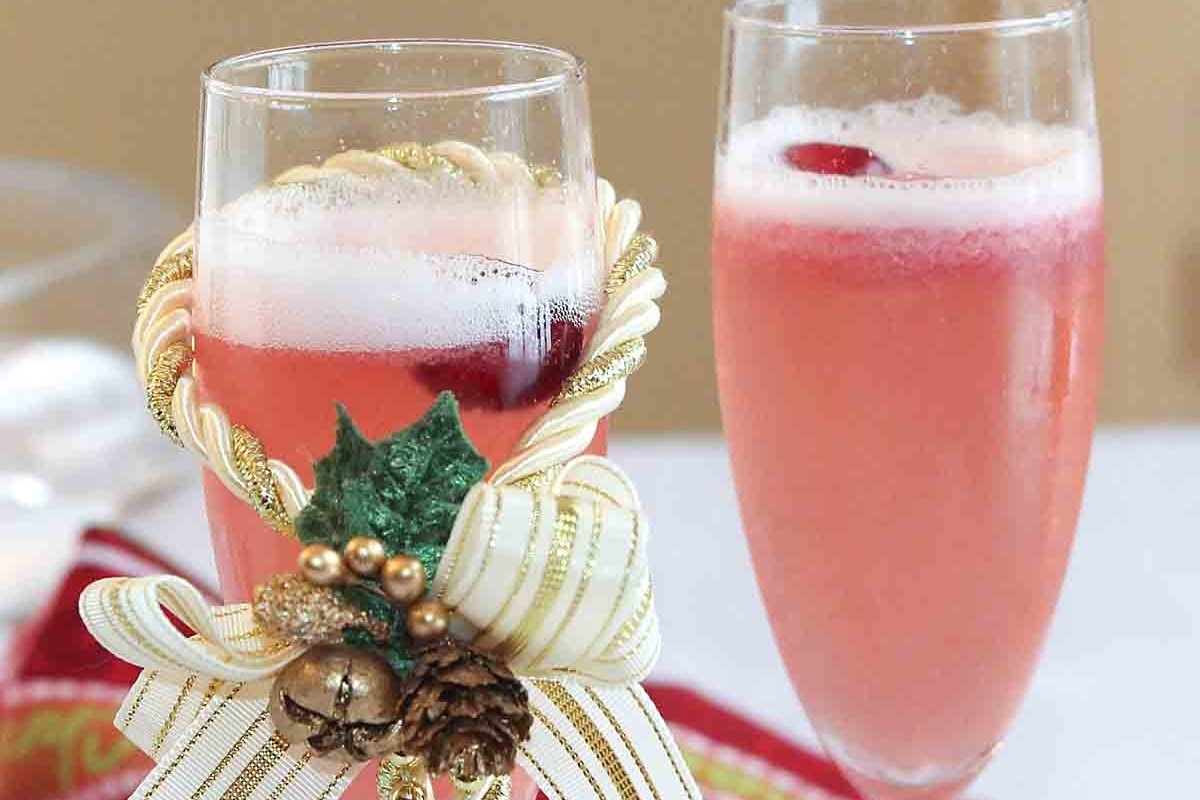 Two glasses of cranberry champagne cocktails on a table.