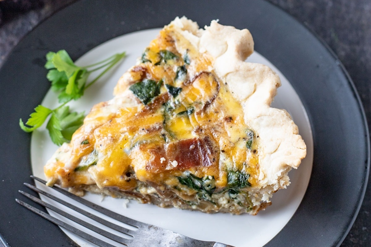 A delicious slice of quiche with spinach and bacon, perfect for those who enjoy savory pies. Don't miss out on this mouthwatering recipe!
