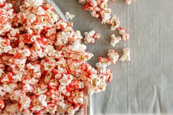 A bowl of popcorn with red and white sprinkles.