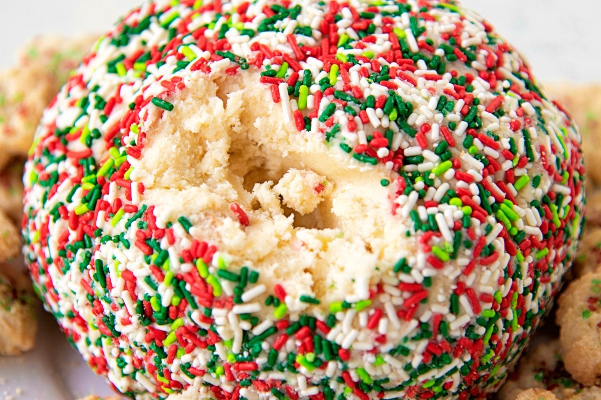 A festive holiday cookie ball adorned with colorful sprinkles, placed delicately on a plate.
