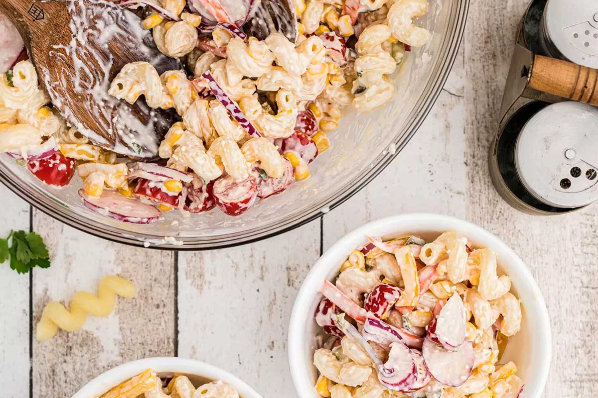 A pasta salad layered with cranberries and corn.