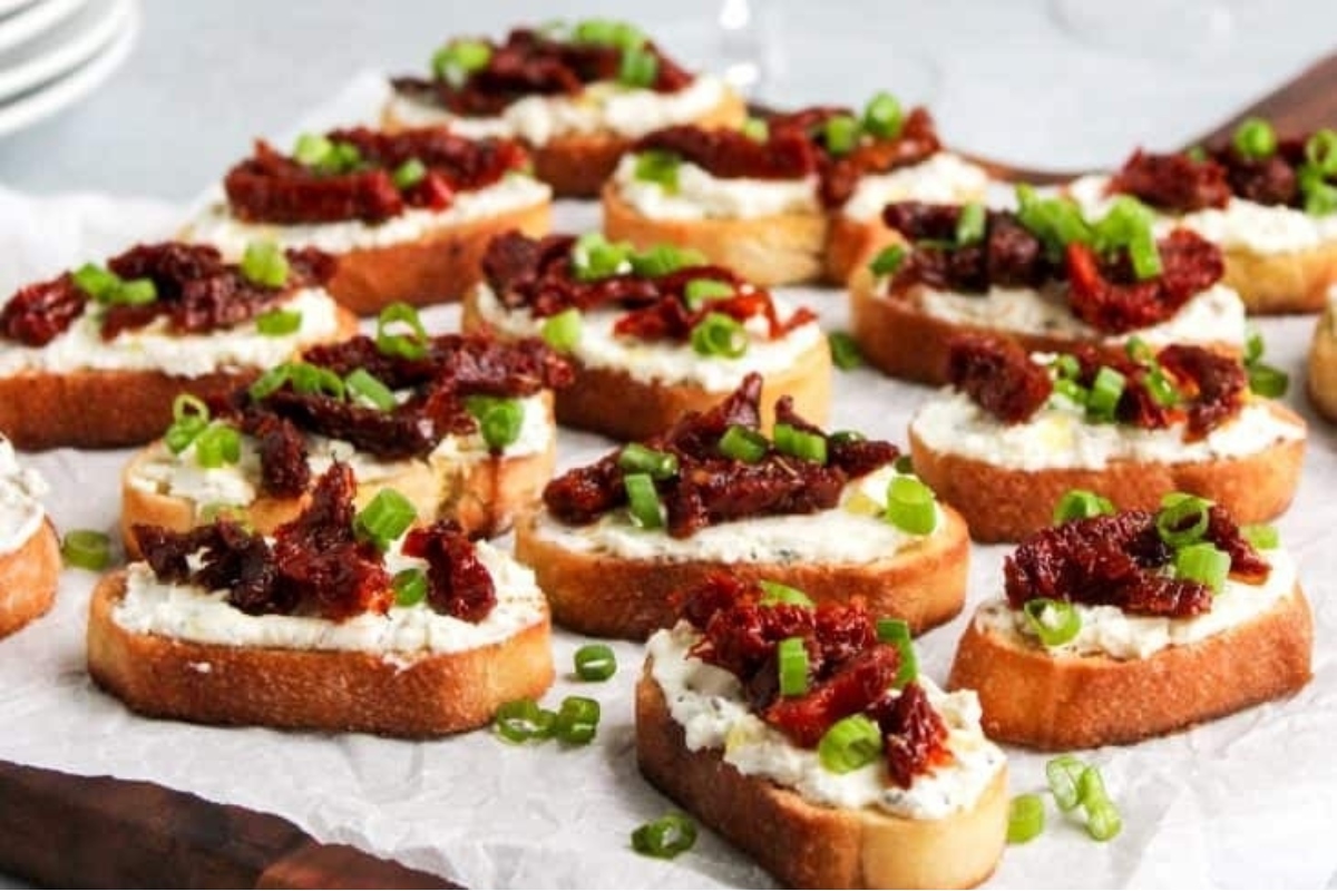 Festive Christmas party appetizers - Roasted red pepper and goat cheese crostini.