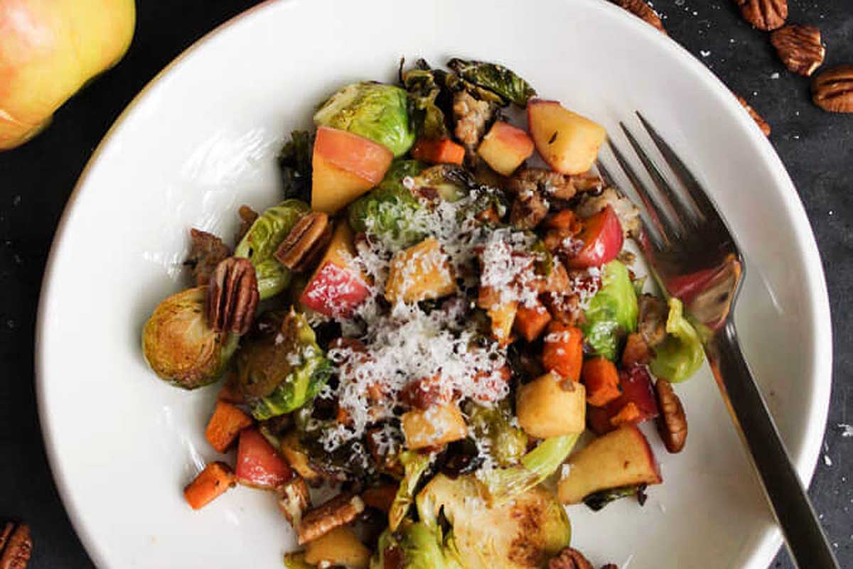 Brussels sprouts, apples and pecans on a plate.