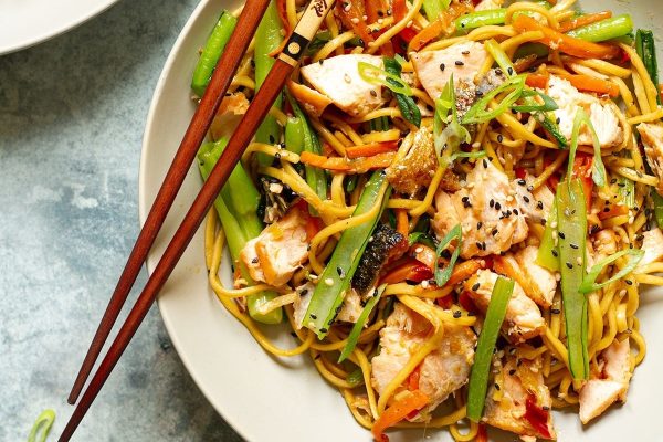 A plate of Asian noodles with chicken and vegetables.