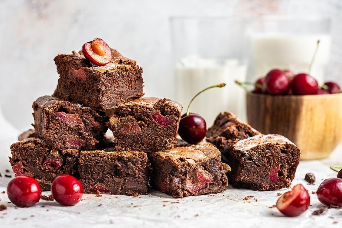 28 Brownie Recipes Chocolate Lovers Will Crave 5 A delicious stack of brownies with cherries on top.