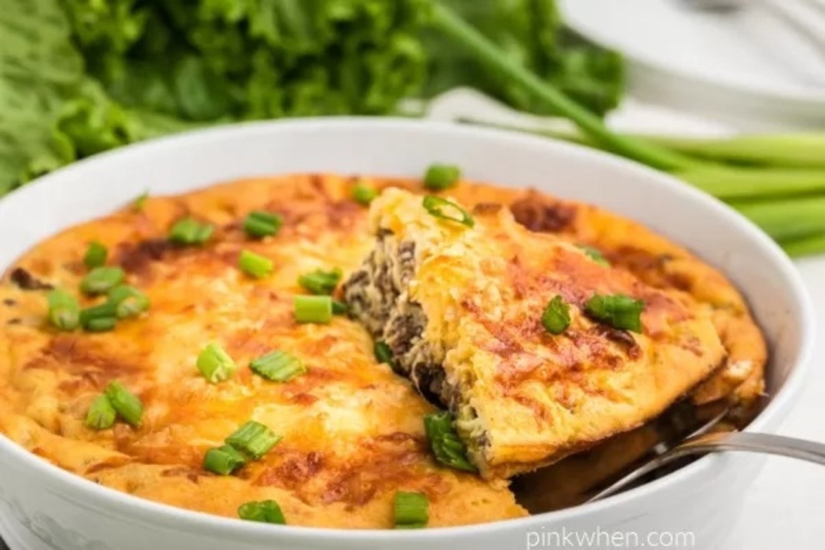 A mouth-watering quiche with a medley of greens elegantly presented on a white dish.