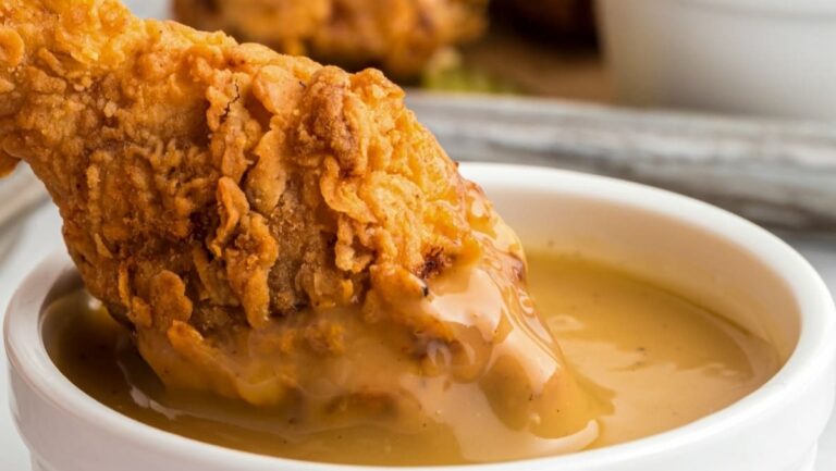 Fried chicken with gravy in a white bowl.