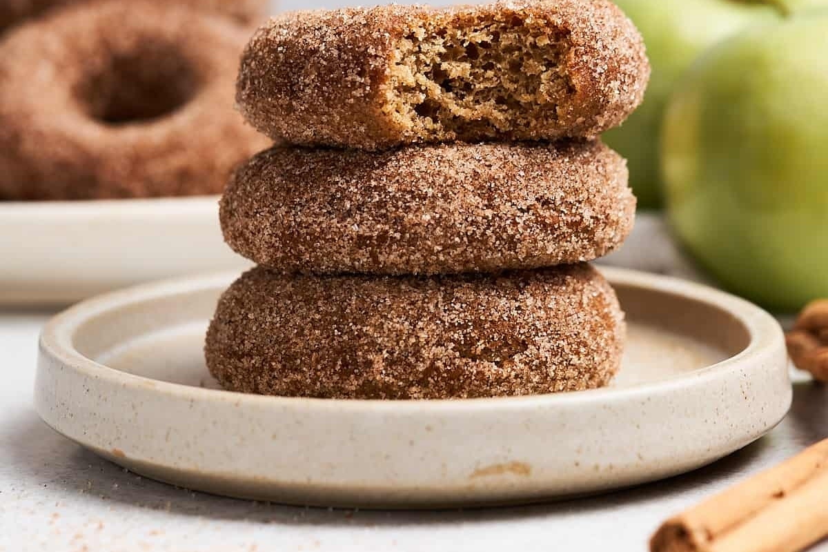 A stack of cinnamon sugar donuts on a plate with Apple Cider Recipes.