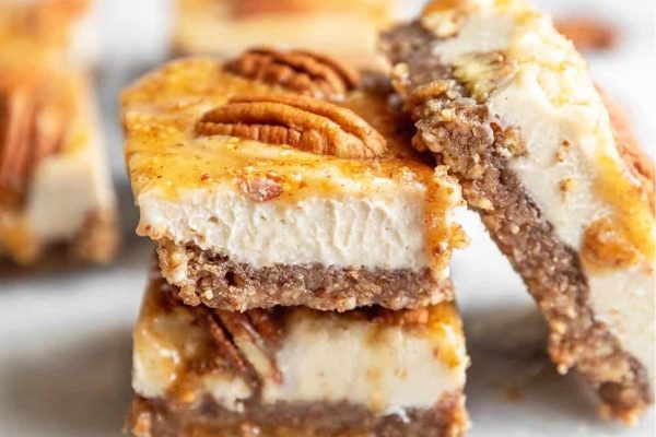 Pecan cheesecake bars stacked on top of each other.