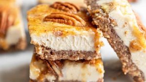 Pecan cheesecake bars stacked on top of each other.
