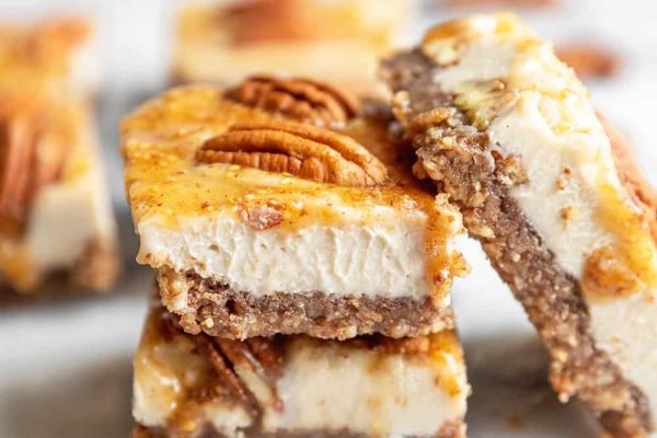 Traditional Christmas dessert - Pecan cheesecake bars stacked on top of each other.