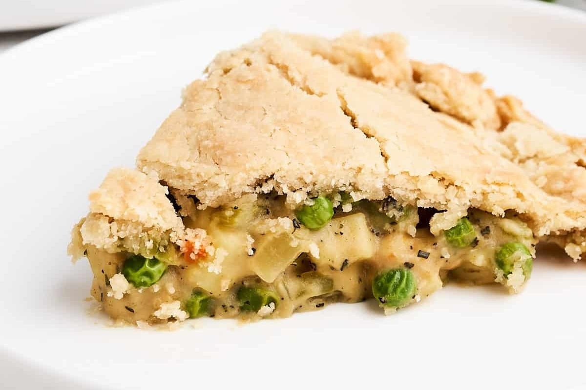 A savory slice of vegetable pie on a white plate.