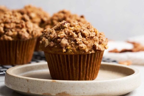 Pumpkin muffins on a plate with a crumb topping.