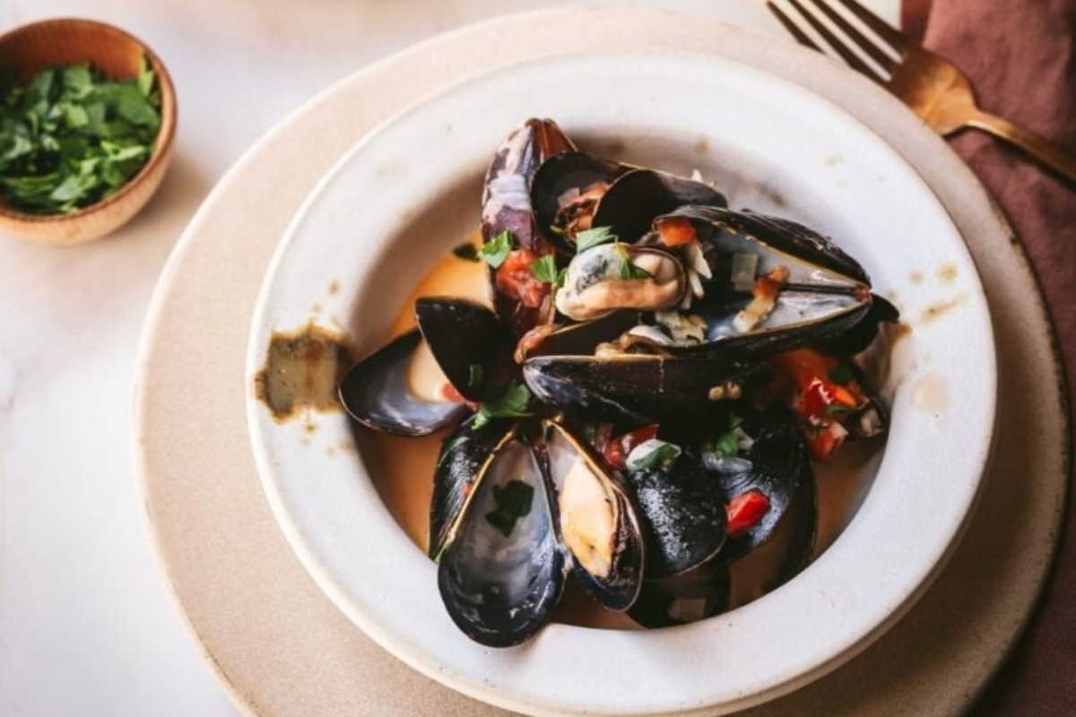 Christmas appetizers - mussels in a white bowl on a table.