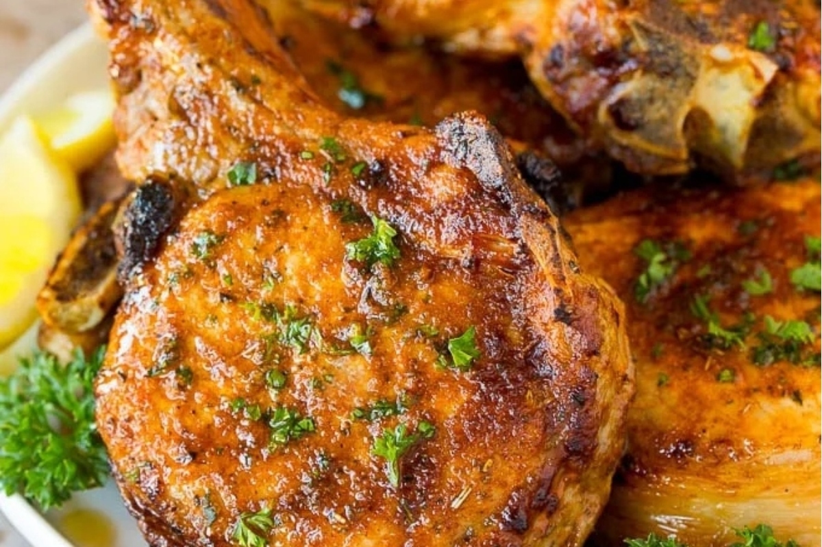 Winter Recipes: Grilled pork chops on a plate with lemons and parsley.