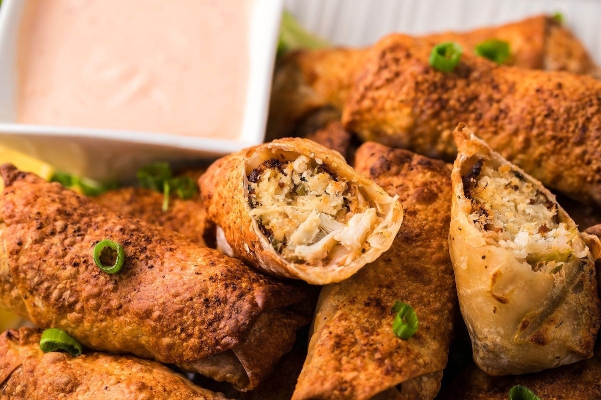 31 Guilt-Free Air Fryer Recipes for Every Meal 2 Chicken spring rolls with dipping sauce on a plate.