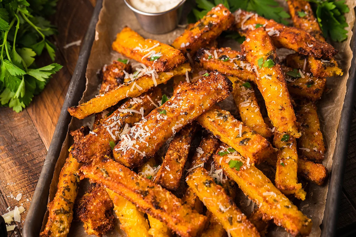 Roasted sweet potato fries on a tray with parsley and parmesan. Perfect for fry enthusiasts seeking new and delicious fry recipes that elevate the traditional fries experience.