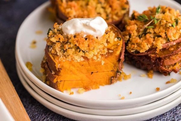 Affordable sweet potato stuffed with crumble and topped with indulgent sour cream, perfect for Thanksgiving or a potluck gathering.