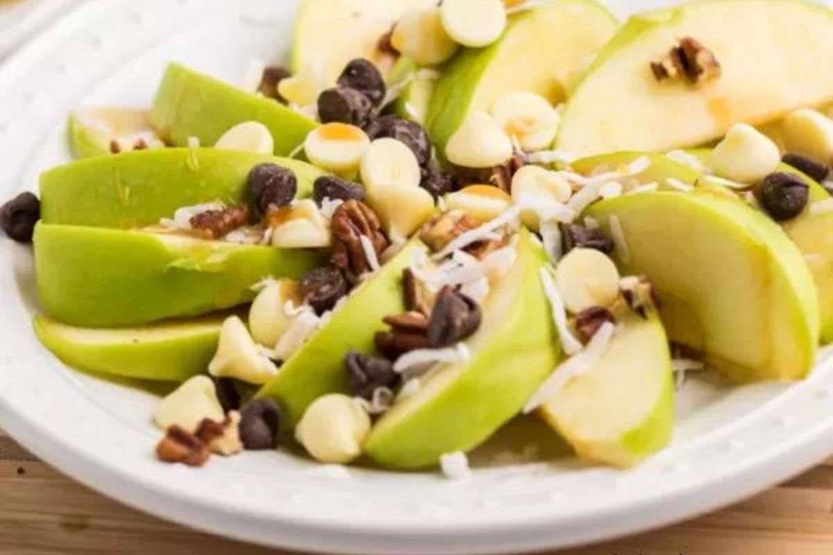 A plate of apple salad with nuts and chocolate chips.