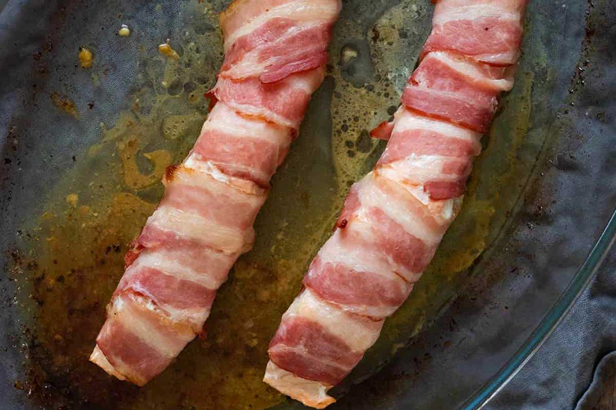 Two pieces of bacon wrapped in bacon on a plate.