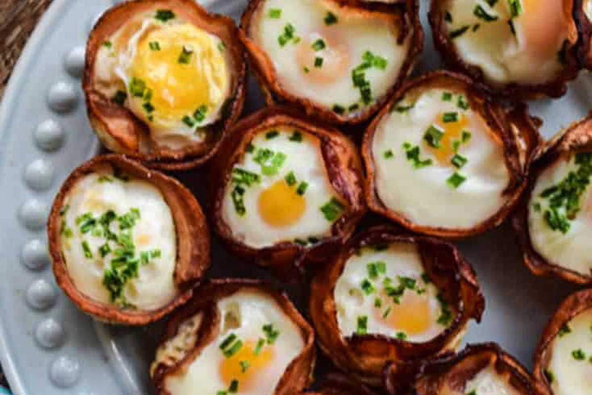 A plate of fried egg cups with chives and parsley.