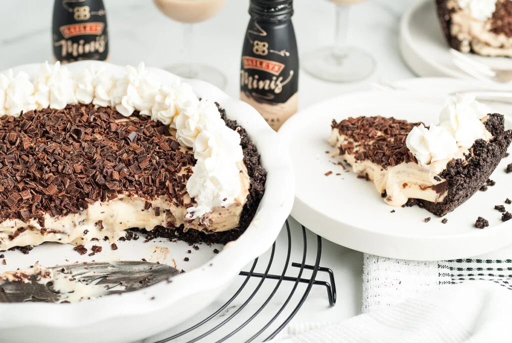 A decadent holiday dessert featuring a No Bake pie filled with chocolate ice cream and topped with a generous dollop of whipped cream.